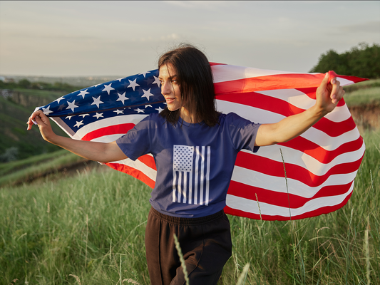 Person holding an American flag in a field
